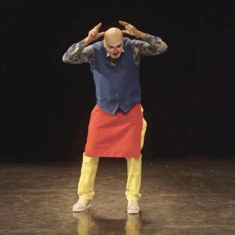 Béchamel, les mains sur la tête, sur scène