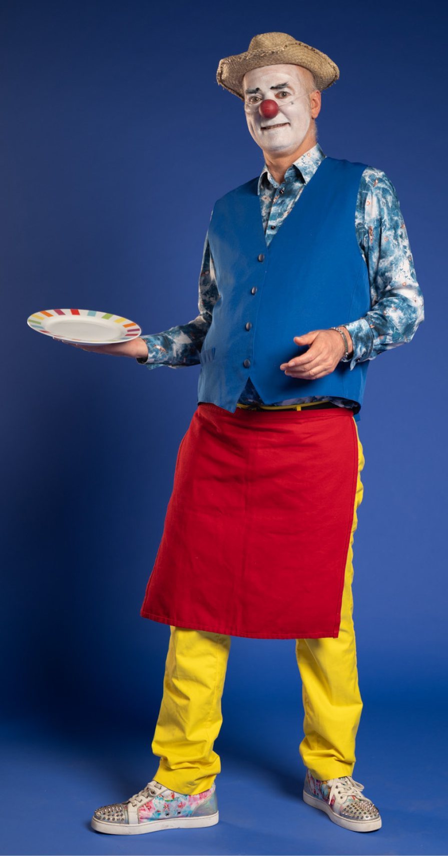 Sébastien Petiot en Béchamel, gilet bleu, tablier rouge, une assiette à la main